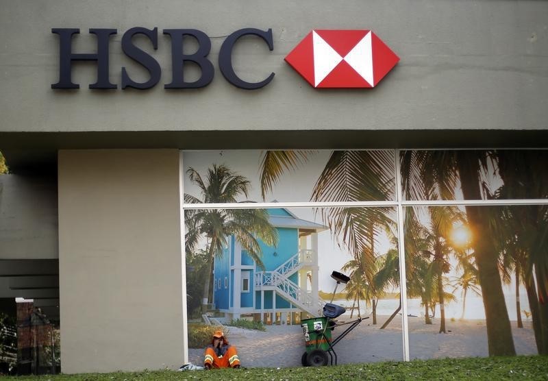 © Reuters. A street sweeper takes a rest outside one of the branches of HSBC in Curitiba