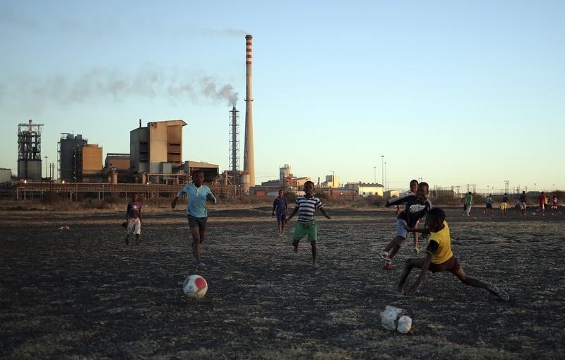 © Reuters. Boys play soccer in Marikana's Nkaneng township in front of the Lonmin's Marikana platinum mine in Rustenburg