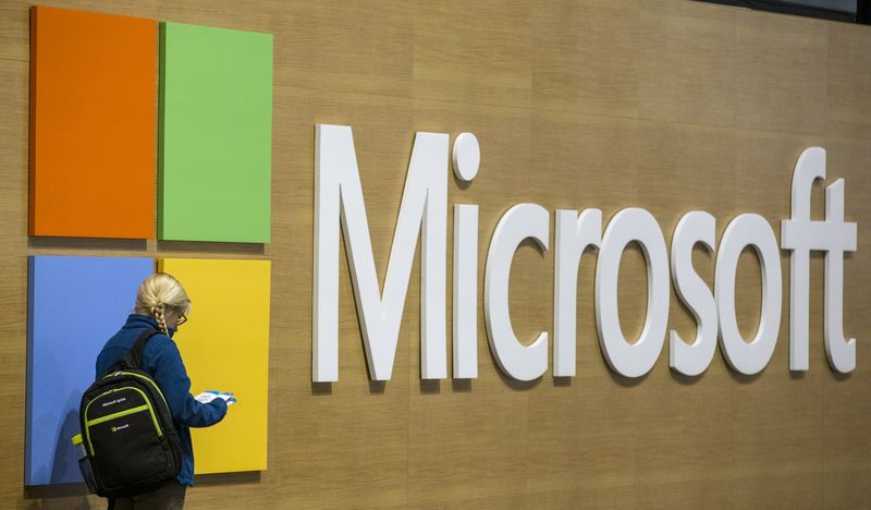 © Reuters. An attendee at the Microsoft Ignite technology conference is seen next to the Microsoft logo in Chicago