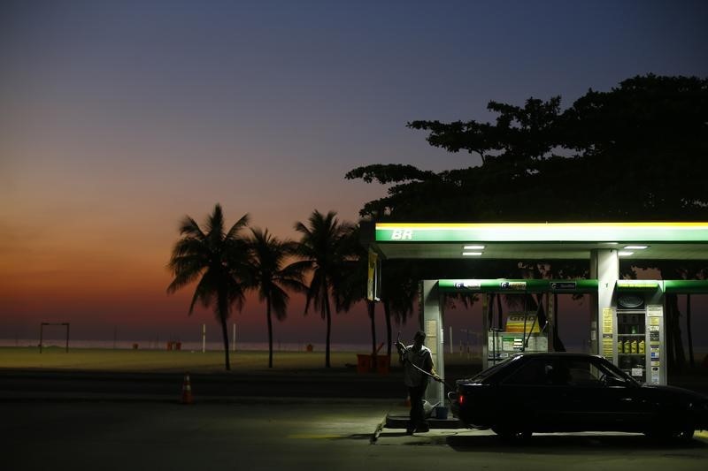 © Reuters. A worker prepares to fill a car at a gas station close to Copacabana beach in Rio de Janeiro