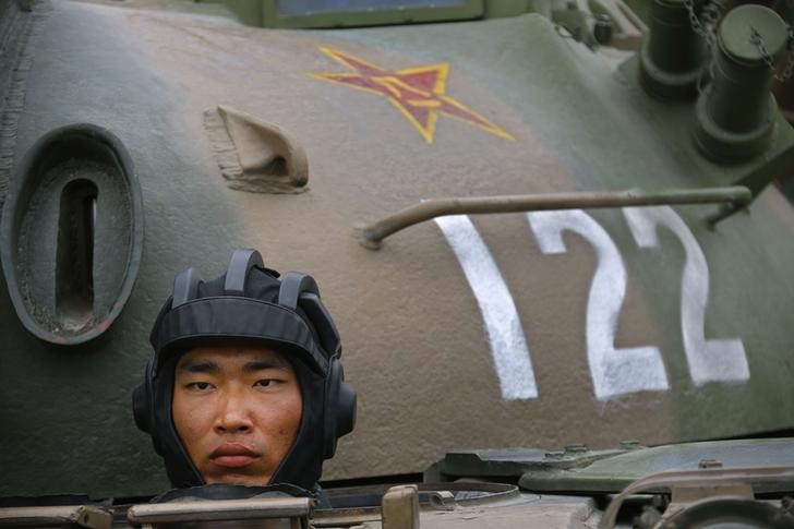 © Reuters. A soldier of People's Liberation Army stands inside a tank in a drill during a organized media tour at a PLA engineering school in Beijing