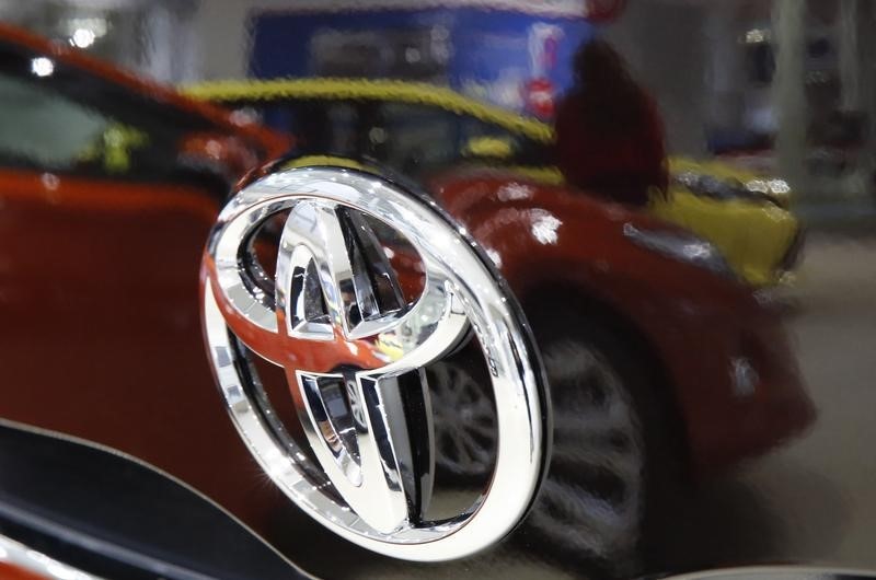 © Reuters. Visitor is reflected on a Toyota car at the company's showroom in Tokyo