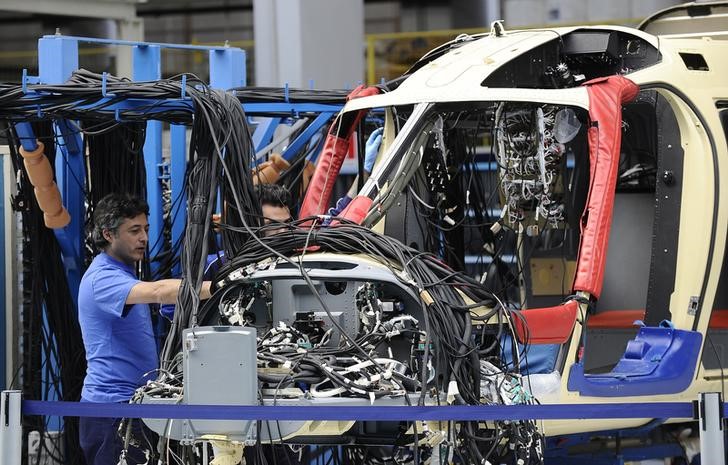 © Reuters. An AugustaWestland employee works on a helicopter at their headquarters in Vergiate