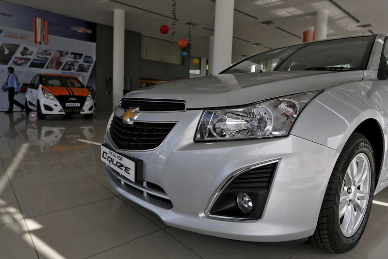 © Reuters. A salesman walks past the Chevrolet cars of General Motors, kept on display inside a showroom in Ahmadabad, India