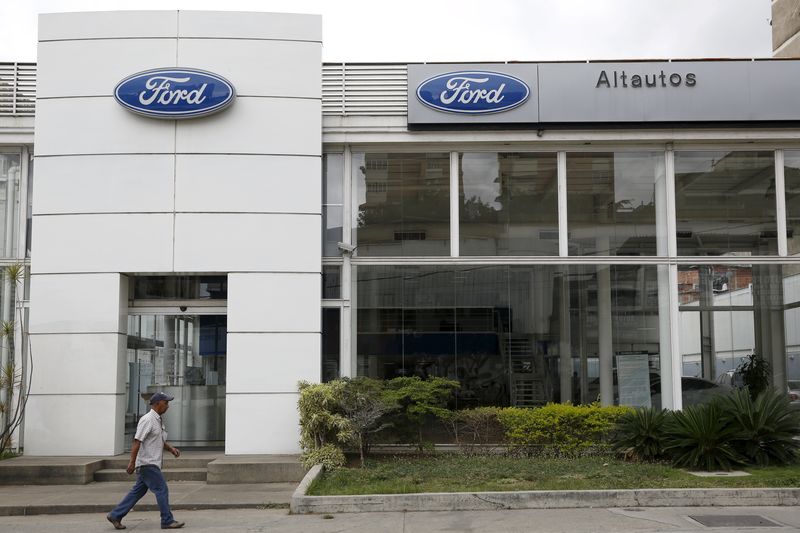 © Reuters. A man walks past a Ford branch in Caracas