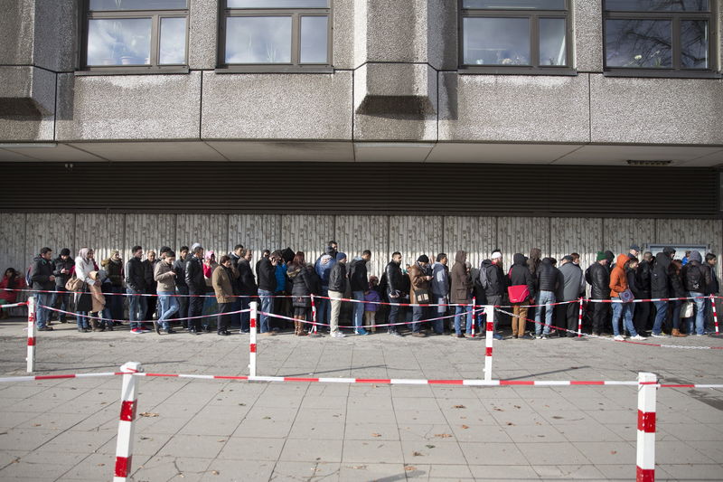 © Reuters. Asylum seekers queue to enter the central receiving facility for refugees in Berlin