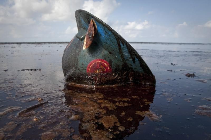 © Reuters. A hard hat from an oil worker lies in oil from the Deepwater Horizon oil spill on East Grand Terre Island, Louisiana