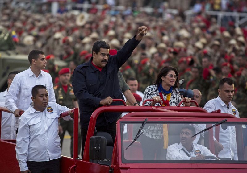 © Reuters. Venezuela's President Nicolas Maduro greets supporters and militia members next to his wife Cilia Flores during a ceremony in Caracas