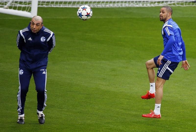 © Reuters. Schalke 04's coach  Di Matteo ducks as Schalke 04's Sam kicks the ball past him during a training session at Madrid's Santiago Bernabeu stadium