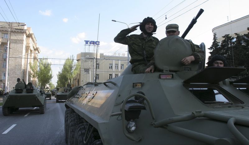 © Reuters. Pro-Russian rebels ride atop an APC during rehearsal for Victory Day military parade in Donetsk