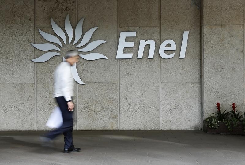 © Reuters. A man walks past the logo of Italy's biggest utility Enel at the Rome's headquarter