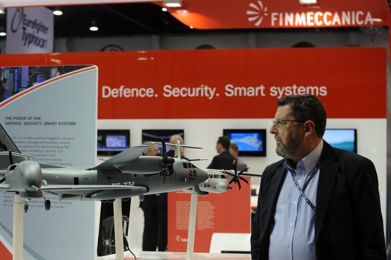 © Reuters. A visitor walks past a stand for Italian defence group Finmeccanica during the IDEX at the Abu Dhabi National Exhibition Centre