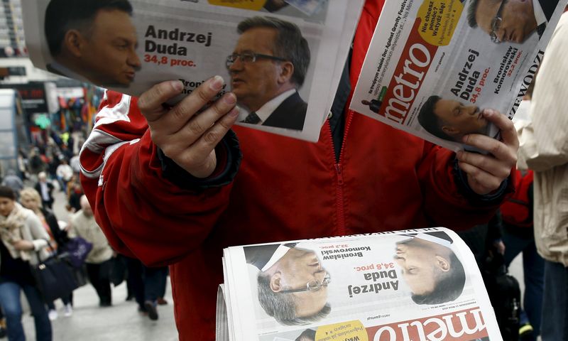 © Reuters. A newsboy distributes newspapers a day after first round of the Polish presidential elections at city center in Warsaw