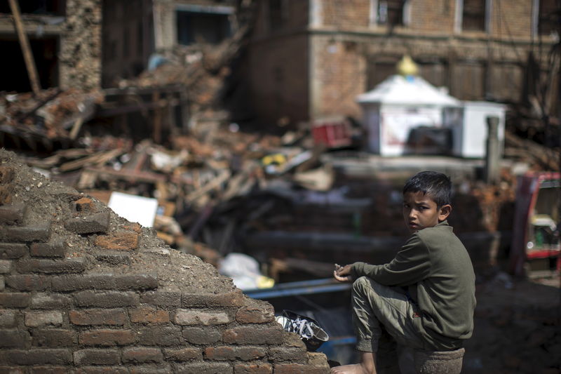 © Reuters. Un bambino, sopravvissuto al sisma del 25 aprile, in un sobborgo di Kathmandu 