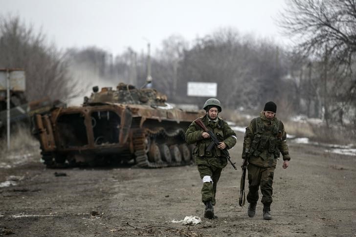 © Reuters. Separatistas pró-Rússia na frente de um veículo blindado destruído, em Vuhlehirsk, na Ucrânia