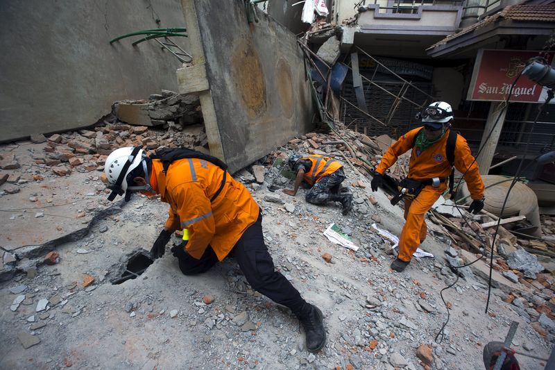 © Reuters. Militares do Nepal durante missão de resgate nos destroços de um prédio, em Katmandu