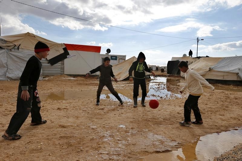 © Reuters. Syrian refugee children play near a tent which was levelled after a heavy snowstorm at Al Zaatari refugee camp in the Jordanian city of Mafraq