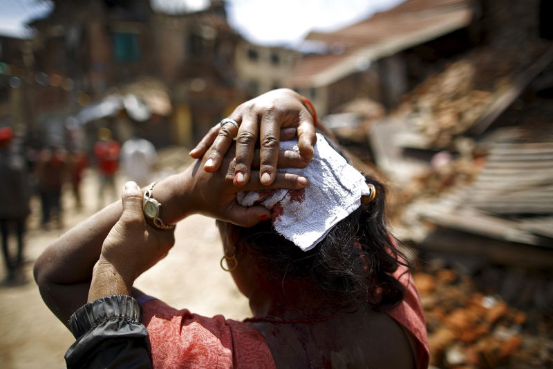 © Reuters. Mulher ferida em terremoto caminha para hospital em Sankhu, no Nepal
