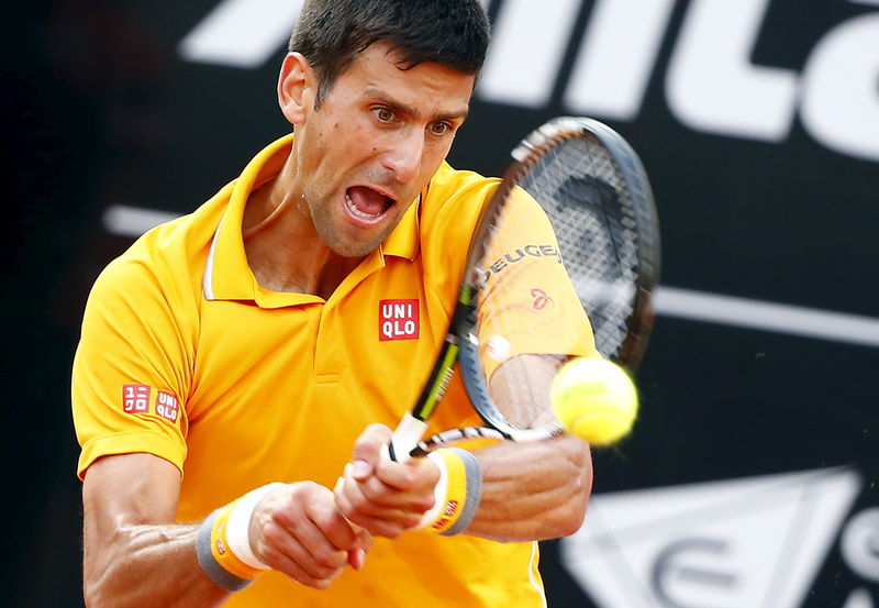 © Reuters. Djokovic of Serbia returns the ball to Almagro of Spain during their match at the Rome Open tennis tournament in Rome