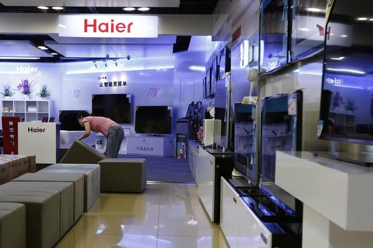 © Reuters. Employee arranges stools at a section displaying Haier television sets inside a Suning store in Shanghai