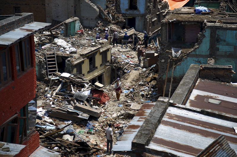 © Reuters. Pessoas caminham em meio a destroços após novo terremoto no Nepal