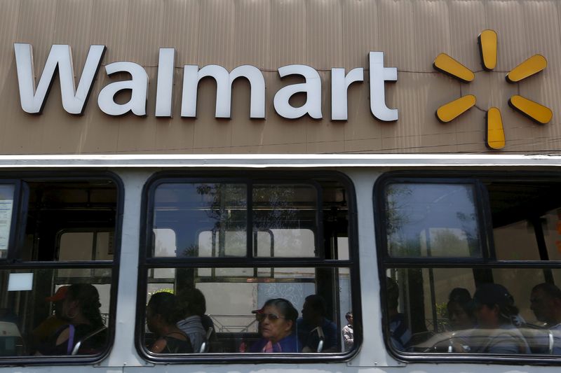 © Reuters. Passengers sit inside a bus in front of a Wal-Mart store in Mexico City 