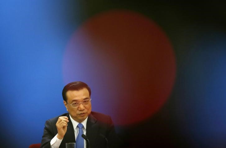 © Reuters. China's Premier Li is seen behind a lamp on TV camera while he answers question from journalist at annual news conference following closing session of National People's Congress, at Great Hall of the People