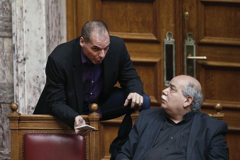 © Reuters. Greek Finance Minister Varoufakis speaks with Interior and Administrative Reconstruction Minister Voutsis during a parliamentary session in Athens