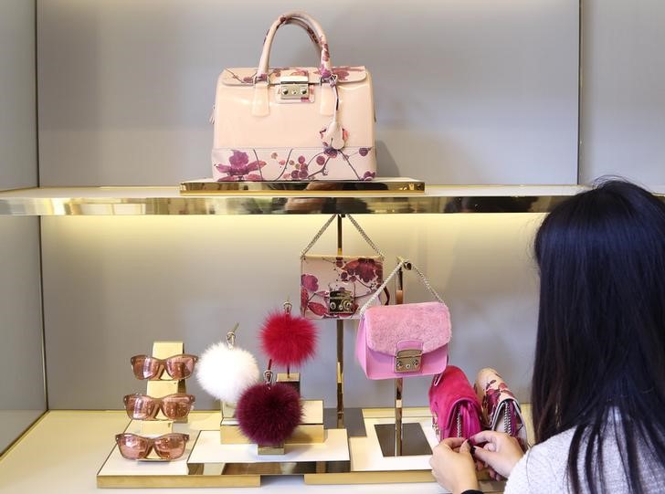 © Reuters. A shop assistant arranges bags in the window at the Furla flagship downtown Milan