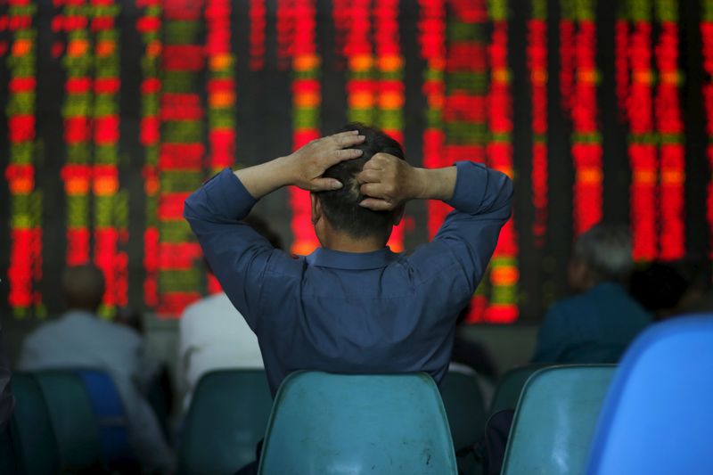 © Reuters. An investor looks at information displayed on an electronic screen at a brokerage house in Shanghai 