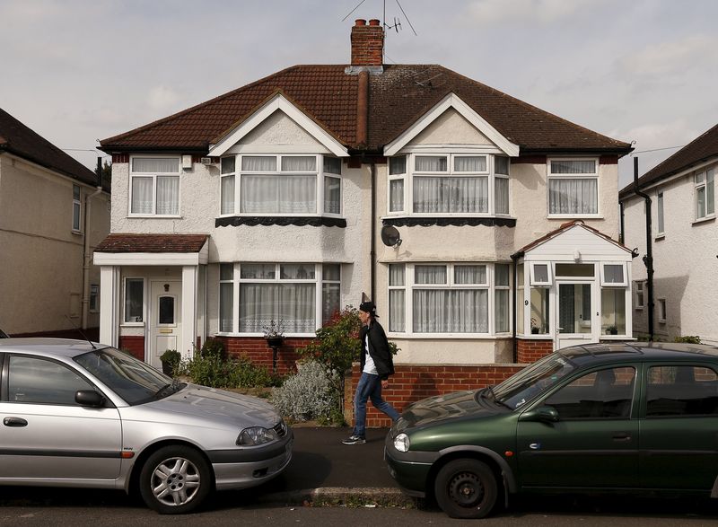 © Reuters. A man walks past the address where Nav Sarao Futures Limited is registered, in London 