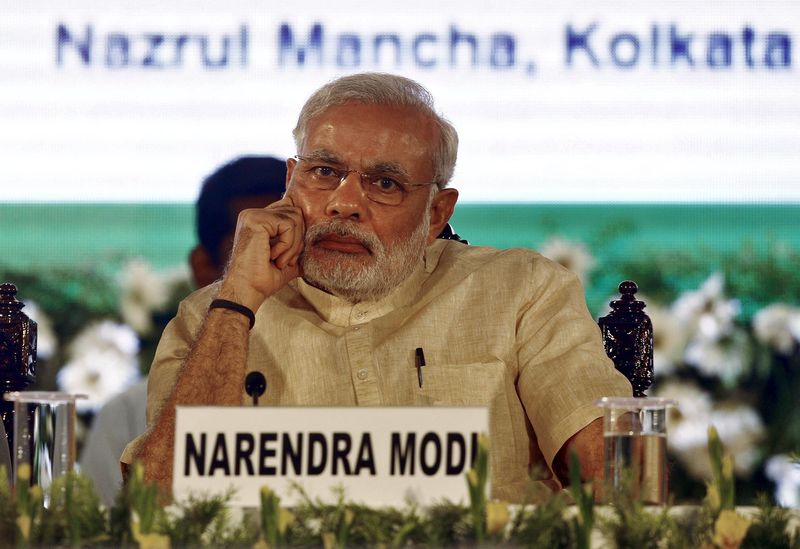 © Reuters. India's PM Modi listens to a speaker ahead of launching three new national social security schemes at a function in Kolkata