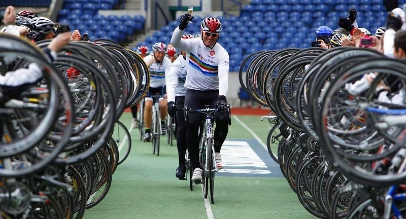 © Reuters. Former England rugby union player Lawrence Dallaglio raises a glass of champagne as he cycles into Murrayfield stadium to complete his "Dallagio Cycle Slam", Edinburgh