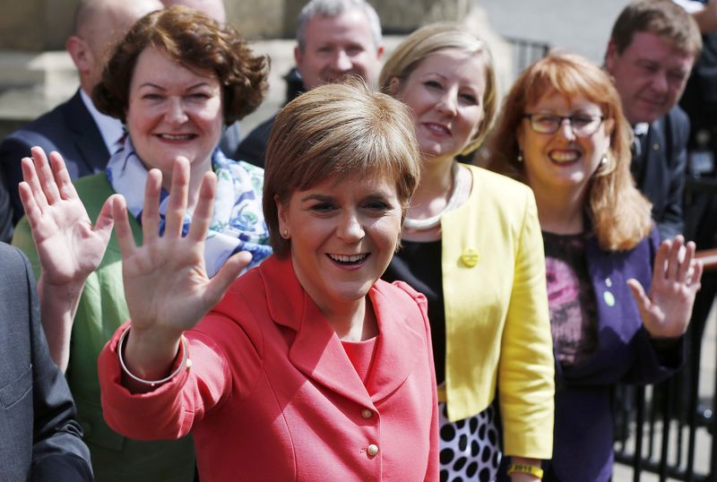 © Reuters. Scotland's First Minister and Scottish National Party leader Nicola Sturgeon waves as she poses with newly-elected SNP MPs in central London