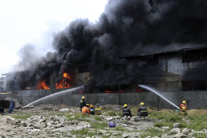 © Reuters. Bombeiros combatem as chamas em incêndio em fábrica perto de Manila