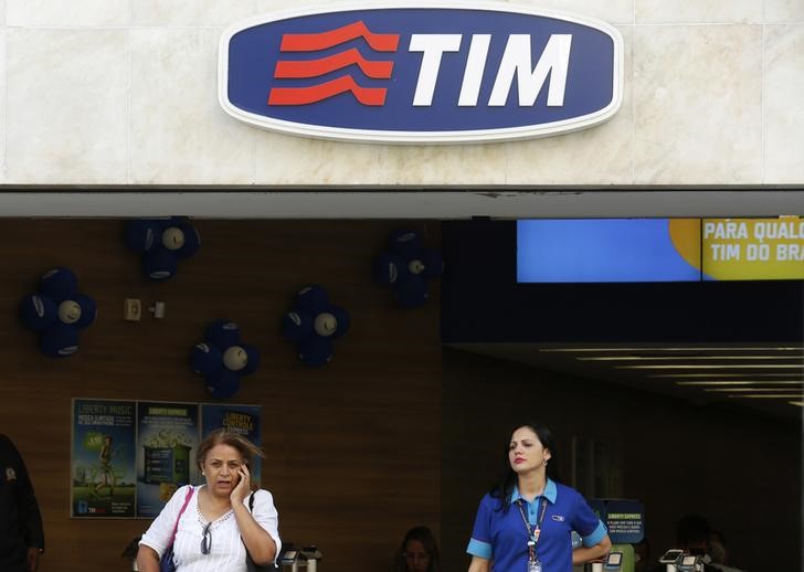 © Reuters. Mulher fala ao celular perto de uma funcionária numa loja da Tim no Rio de Janeiro