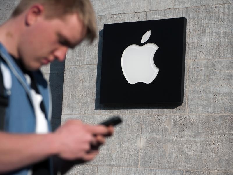 © Reuters. An Apple logo is seen in front of an Apple Store as a customer waits to enter, in Berlin