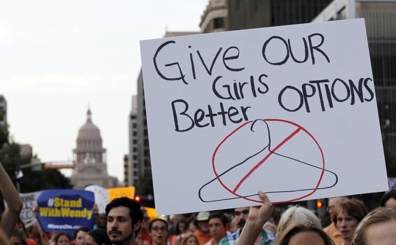 © Reuters. Protesters carry signs during an abortion rights march in Austin