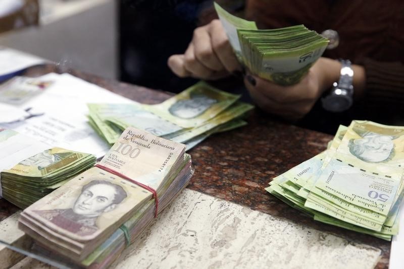 © Reuters. A cashier counts bolivars at money exchange in Caracas