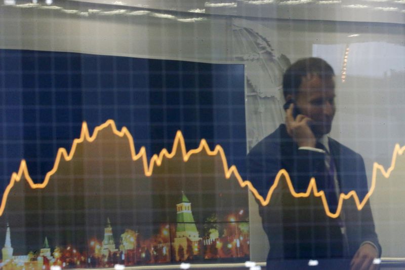 © Reuters. File photo of a participant reflected in a display showing business and financial information at the VTB Capital "Russia Calling!" Investment Forum in Moscow