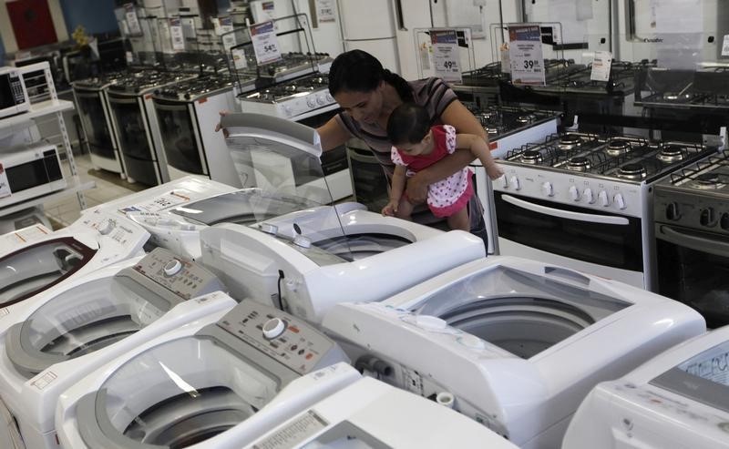 © Reuters. Mulher e filha olham máquina de lavar numa loja das Casas Bahia, em São Paulo