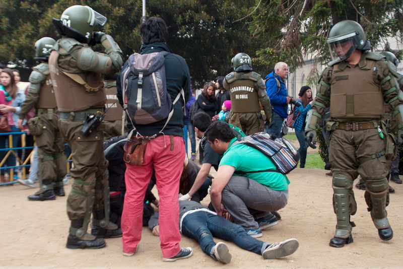 © Reuters. Estudantes socorrem colega baleado em manifestação em Valparaíso, no Chile