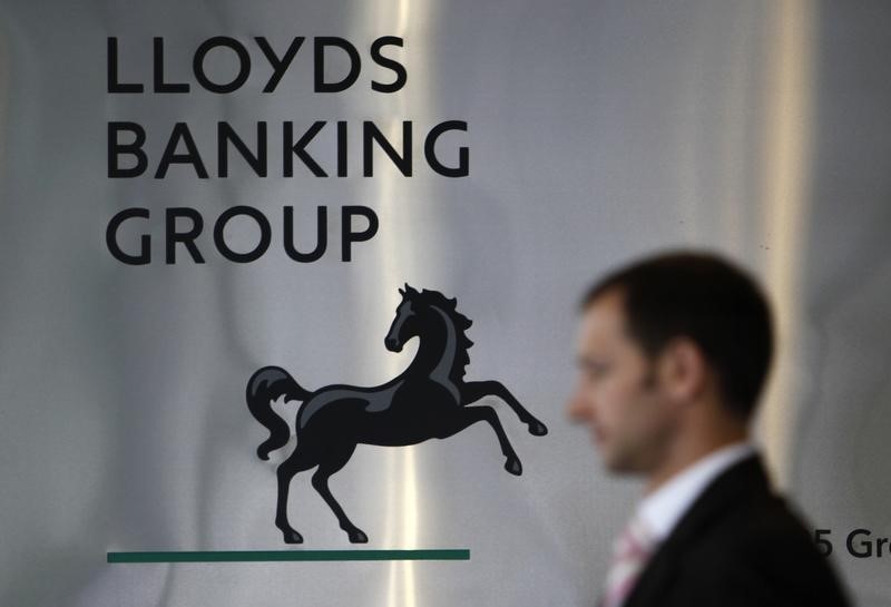 © Reuters. File photograph shows a pedestrian passing the head office of the Lloyds Banking Group in London