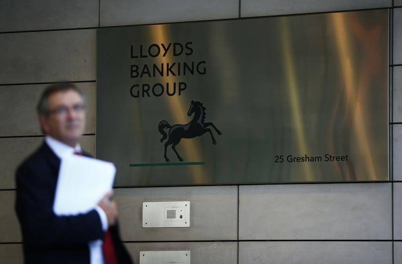 © Reuters. A man waits outside the corporate headquarters of Lloyds Banking Group in the City of London