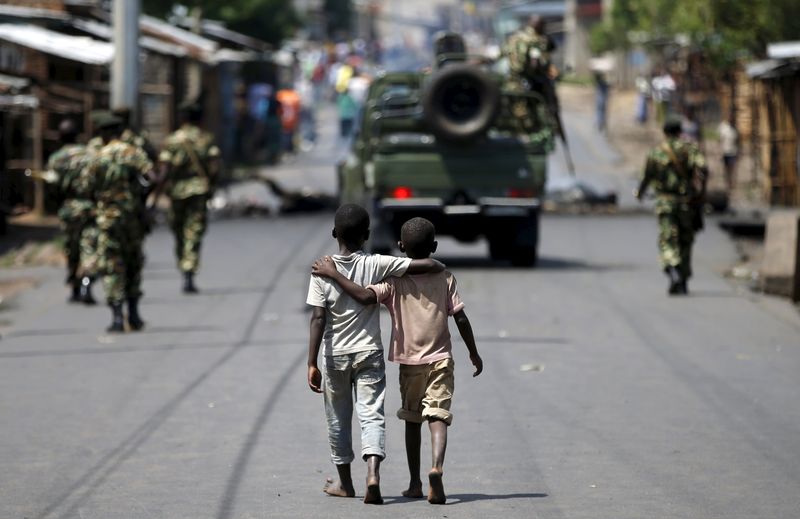 © Reuters. Meninos caminham atrás de soldados de Burundi em Bujumbura