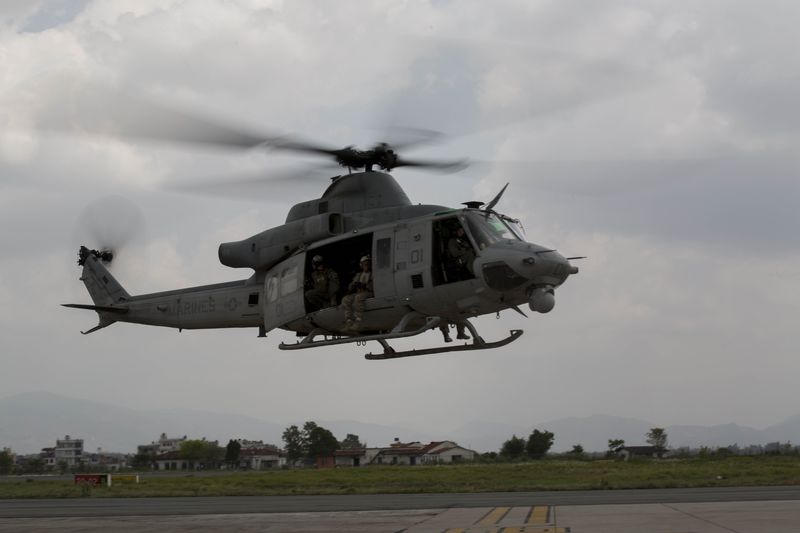 © Reuters. A UH-1Y Huey helicopter flies into the Tribhuvan International Airport after a search and rescue operation in Kathmandu Nepal