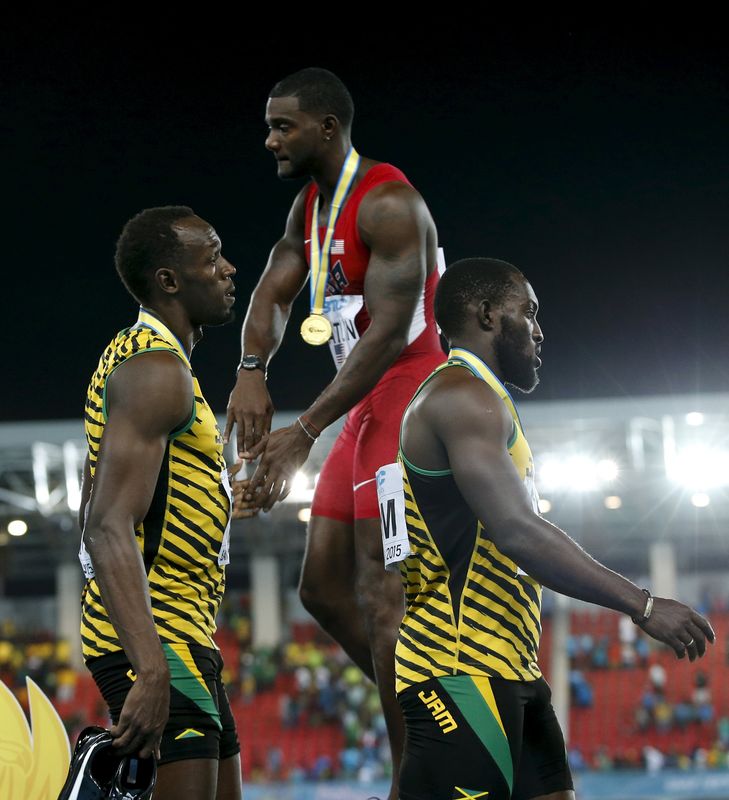 © Reuters. Gatlin of the U.S. shakes hands with Jamaica's Bolt on the medals podium after the U.S. won the 4x100 meters race at the IAAF World Relays Championships in Nassau