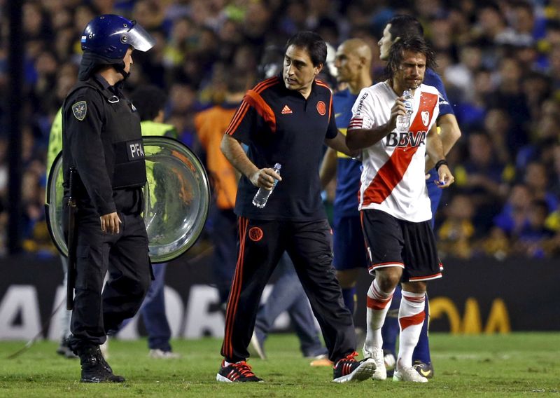© Reuters. Leonardo Ponzio del River Plate camina con un asistente del club antes del segundo tiempo del partido contra Boca Juniors por la Copa Libertadores