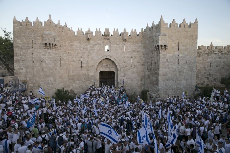 © Reuters. Israelis hold flags as they take part in a march marking Jerusalem Day outside Jerusalem's Old City