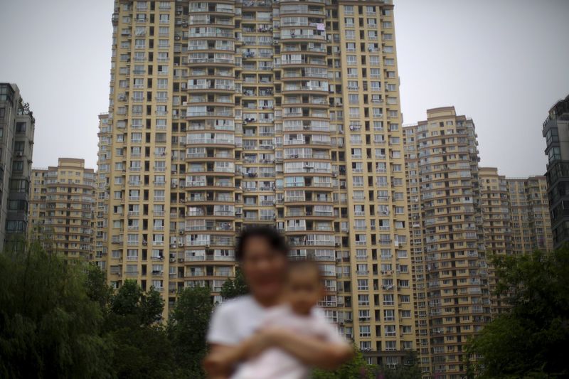 © Reuters. File photo of a woman holding her son in a playground in a residential area in Shanghai